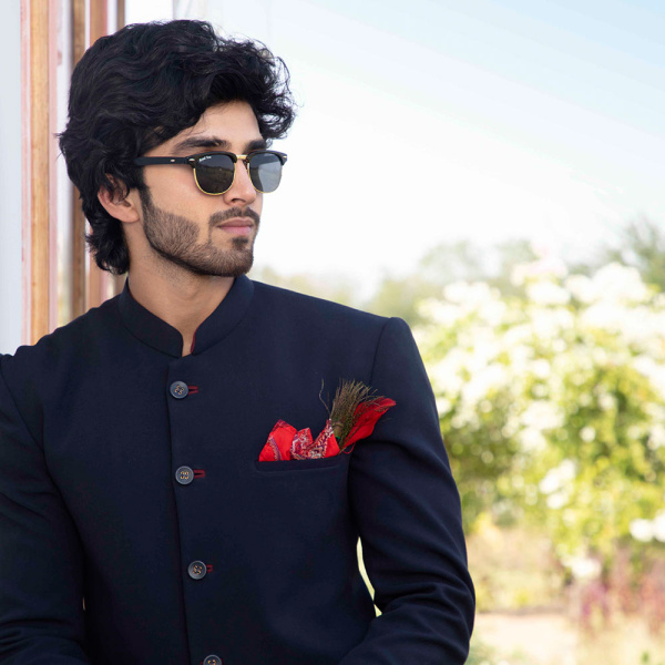 Royal blue bandhgala accessorised with pocket square & peacock feather brooch