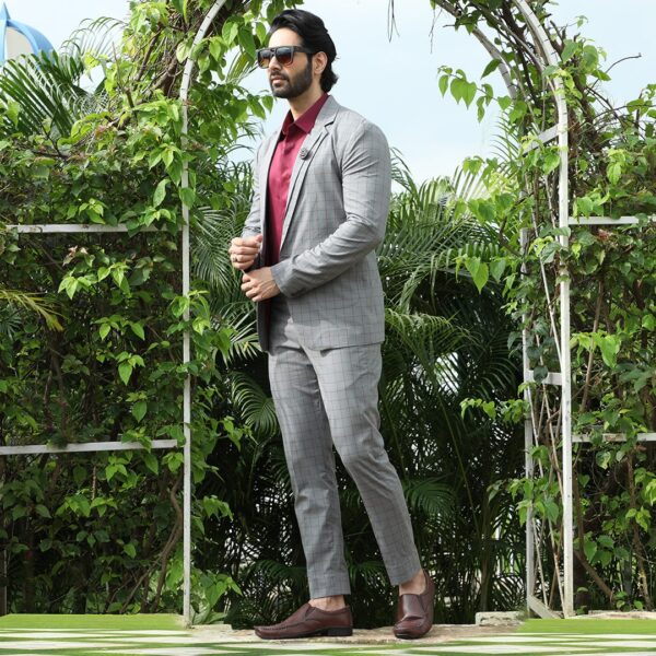 An ash grey checks blazer with single button and dual lapel. It is enhanced with two down patch pockets.