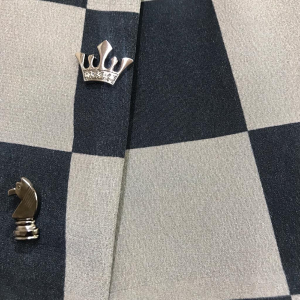 Chequered Blazer accessorized with chess piece brooches in gold. - Image 3