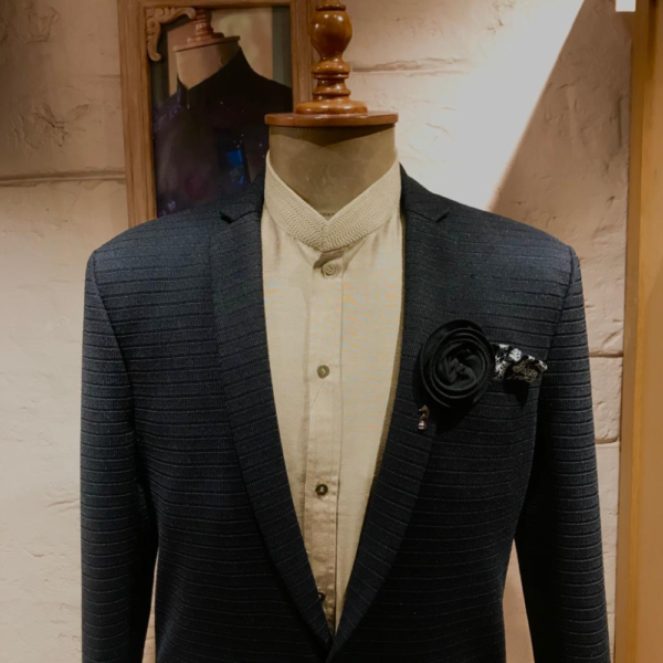 Black horizontal stripe textured blazer. It is accessorized with a chess piece brooch and a fabric flower. A chess embroidered pocket square completed the look. - Image 3