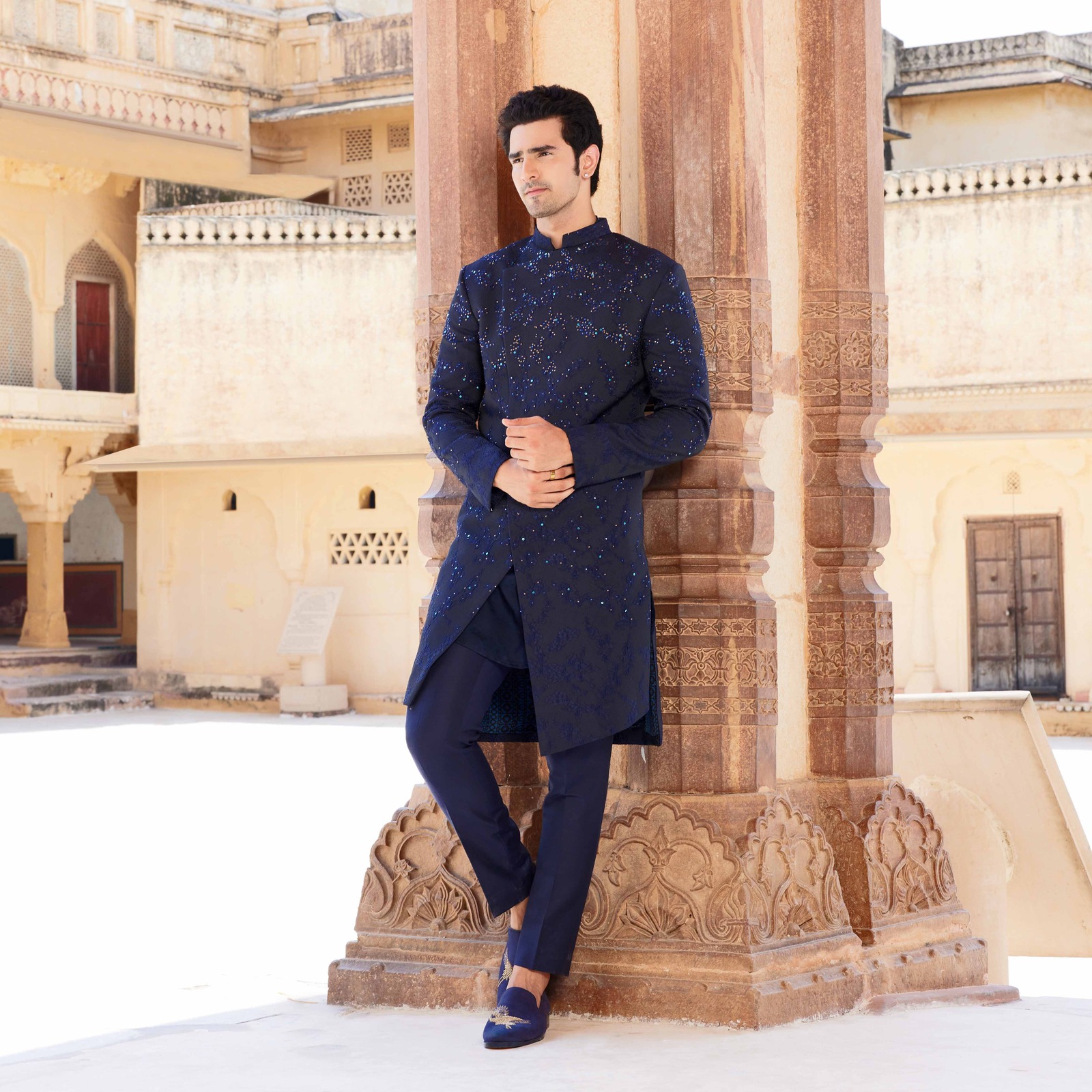 Midnight blue overlapped asymmetrical textured bandhgala with sequence detailing paired with coordinated short kurta. Matching trousers for bottom. Styled with coordinated loafers with antique gold embroidery