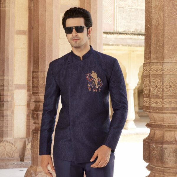 Midnight Blue Jodhpuri coat with surface detailing of Shield embroidery all over. Knight motif in antique gold on one side. Matching trousers for bottom. Styled with matching form shoes. - Image 2