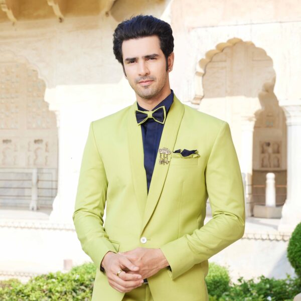 Celery green tuxedo suit with stitch line detailing on the placket paired with a midnight blue shimmer shirt. Accessorised with coordinated pocket square, brooch and bow tie. Styled with coordinated formal shoes. - Image 2