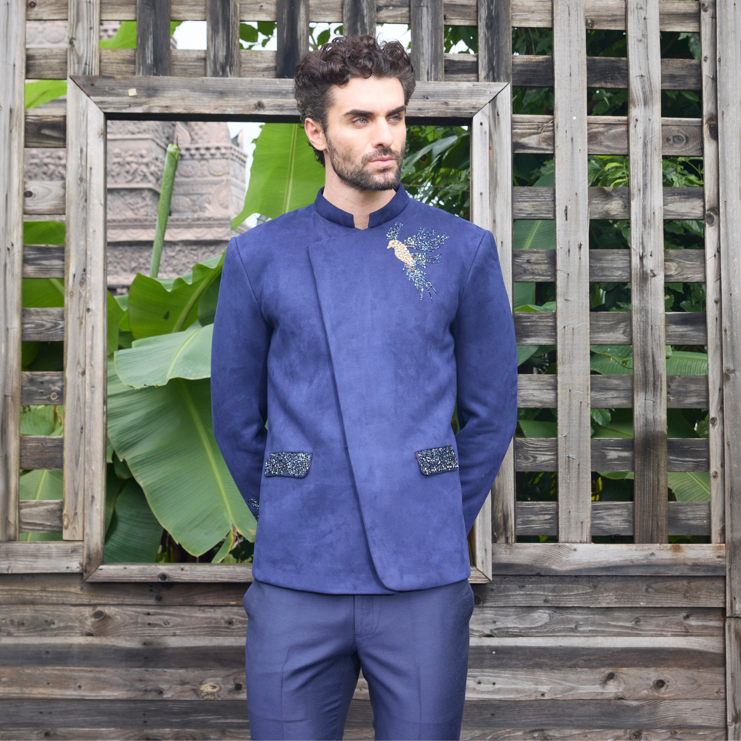 Midnight blue velvet Jodhpuri with Bird of Paradise motif on one shoulder and sleeve. Paired with matching trouser.