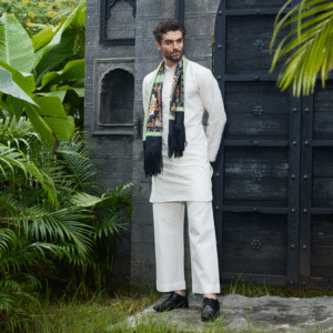 Off white short kurta with surface detailing of Medieval embroidery all over. The ensemble is paired with matching trouser & accessorised with a scarf.