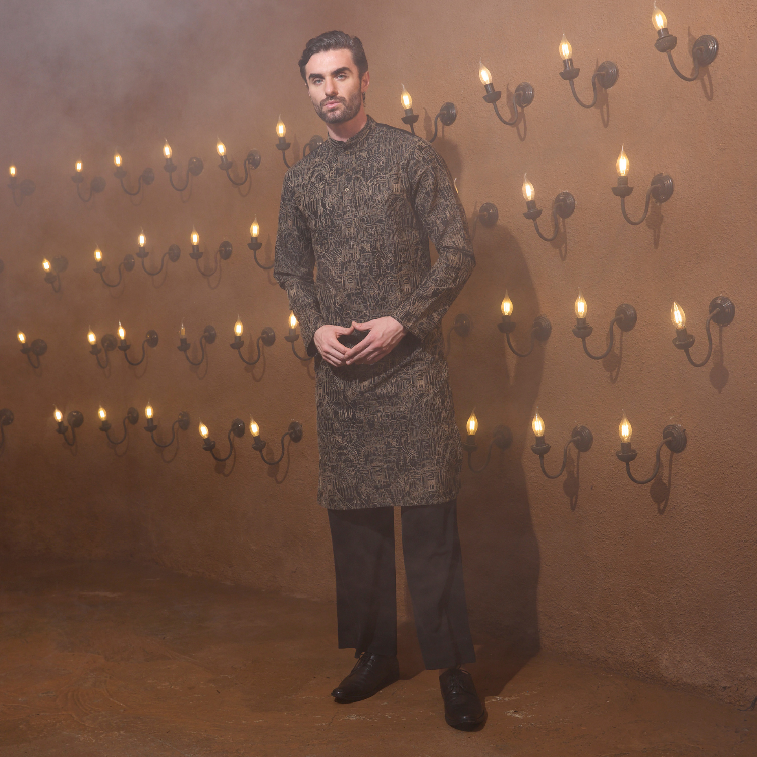 All over surface detailing kurta of Medieval embroidery in antique colour. The enseble is teamed up with black trouser.