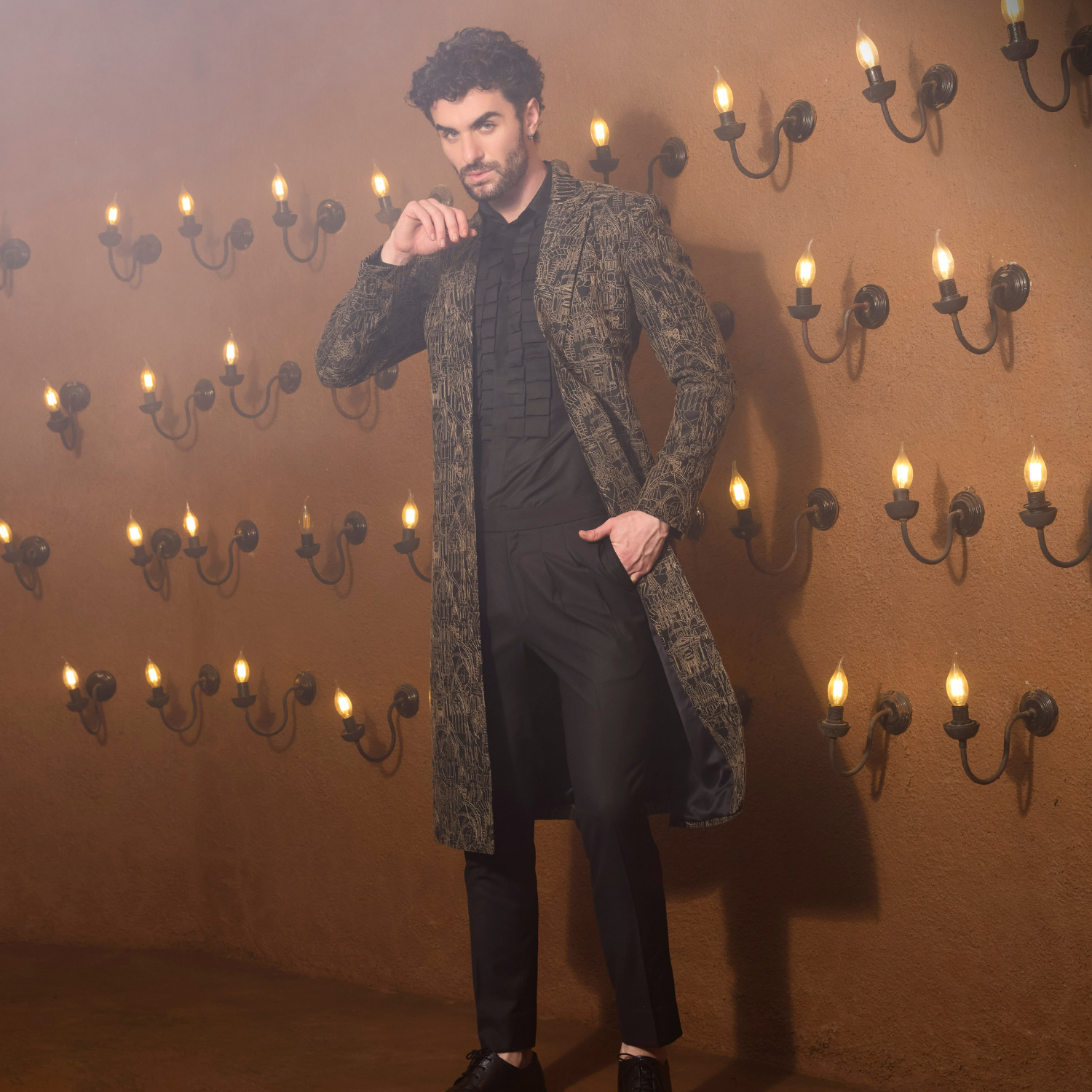 Black Long coat with full surface deatailing of Medieval embroidery. The ensemble is teamed up with Vintage shirt & heritage pleated trouser.