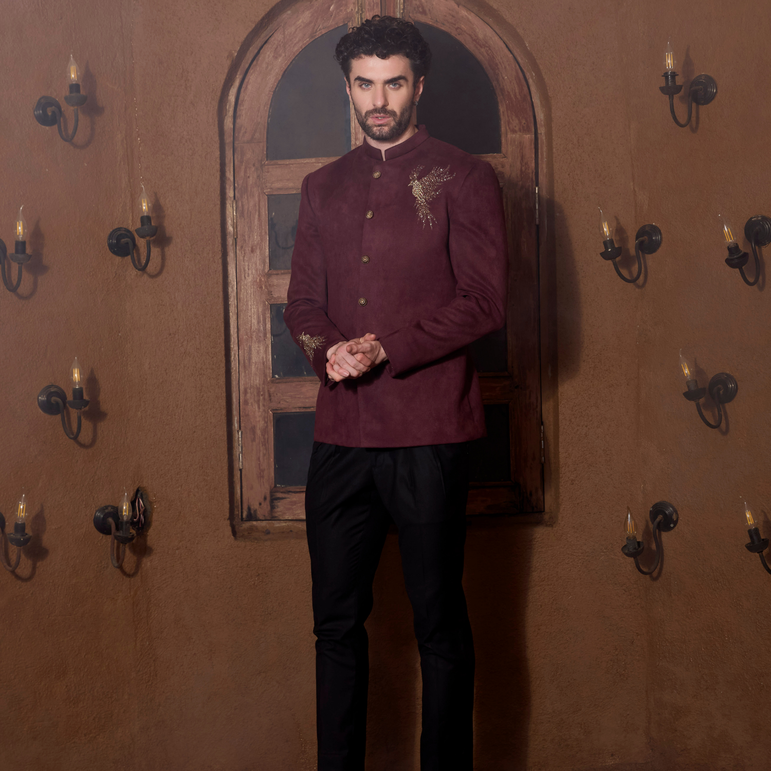 Plum velvet Jodhpuri with Bird of Paradise motif  embroidered in sequins & pearl on one shoulder & sleeve. The outfit is paired with antique gold trouser.