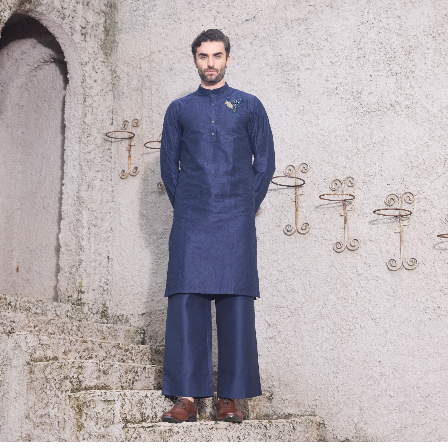 Midnight blue kurta with Birds of Paradise motif embroidered with sequins & thread on one shoulder and sleeves. Paired with midnight blue trouser.