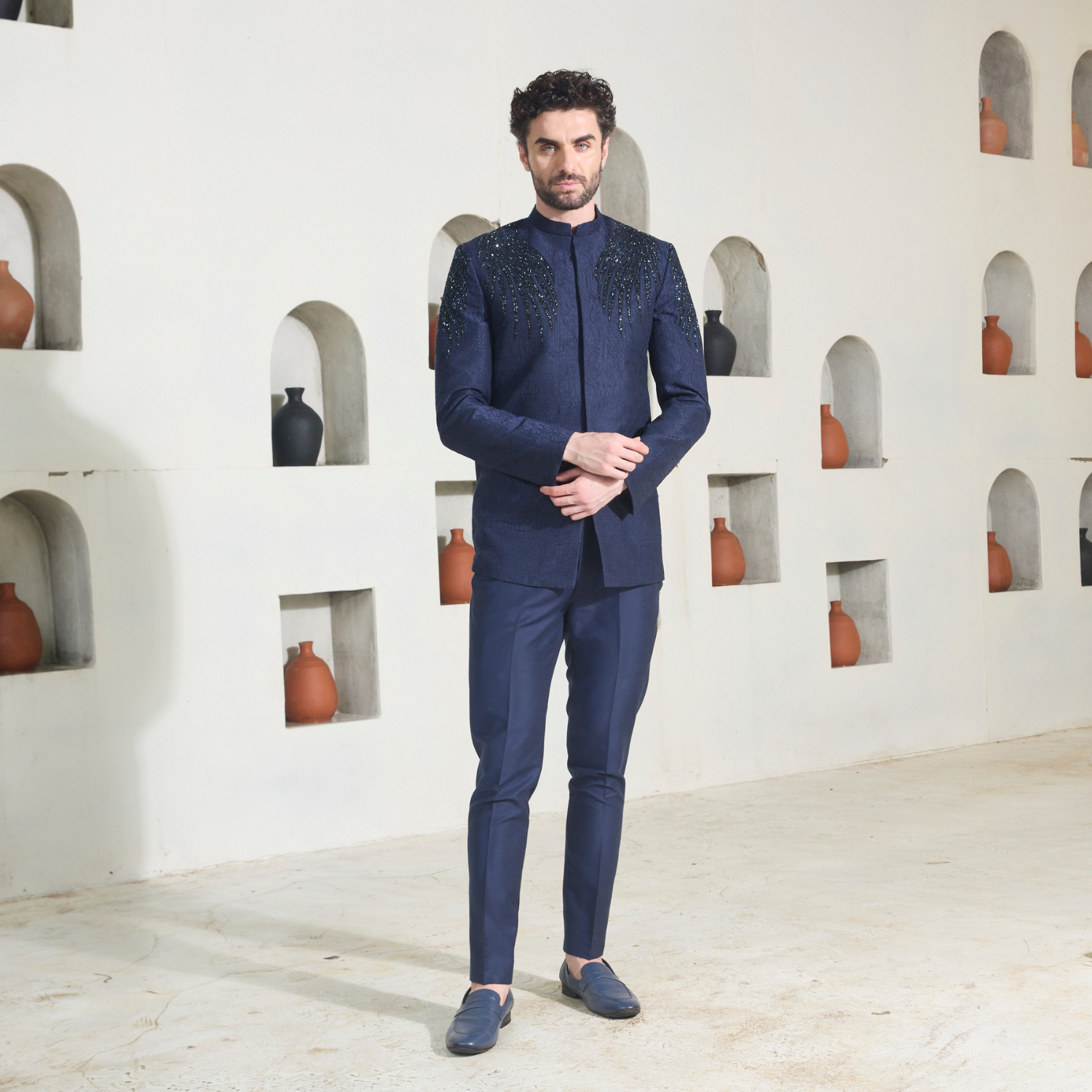 Midnight blue Jodhpuri with all over surface detailing of Quatrefoil in monotone look. Wings of Eternity embelished in bugle beads on shoulder & sleeve. The ensemble is paired with midnight blue trouser.