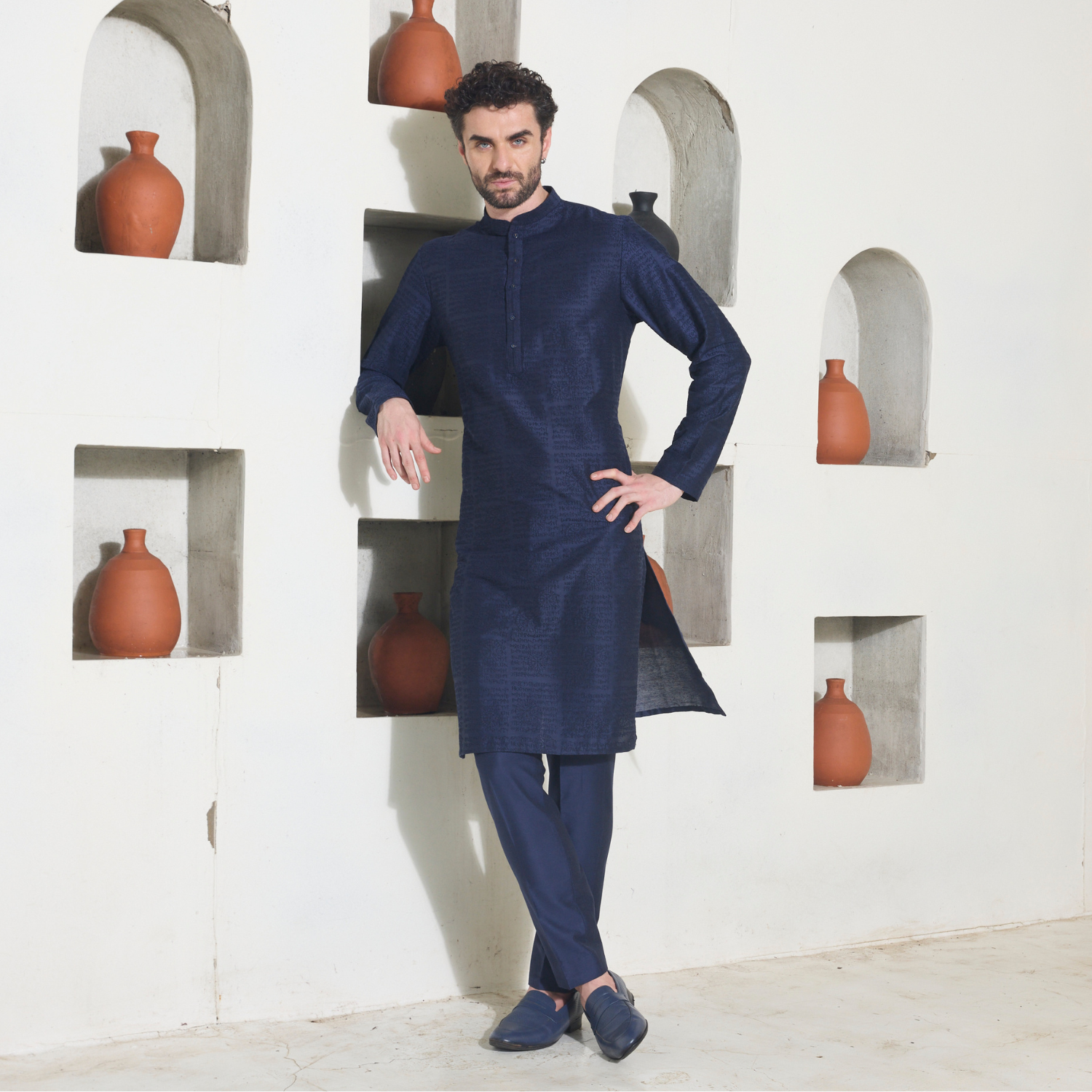 Midnight blue Kurta with all over surface detailing of Runes embroidered in monotone look. The enseble is teamed up with midnight blue trousers.