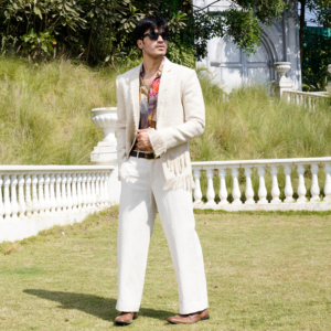 Ivory textured jute blazer with fray detailing on sleeve, hem and pocket flap. Paired with abstract floral printed shirt and coordinated flared trouser.